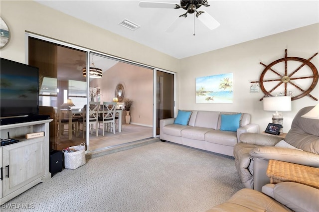 living room featuring carpet, visible vents, and a ceiling fan