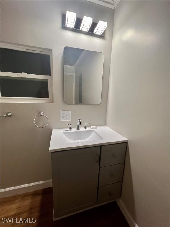 bathroom featuring vanity, baseboards, and wood finished floors