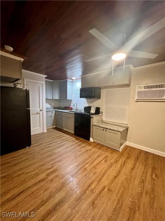 kitchen with light wood-style floors, wooden ceiling, baseboards, and black appliances