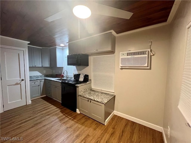 kitchen featuring wood finished floors, a sink, gray cabinetry, and a wall mounted AC