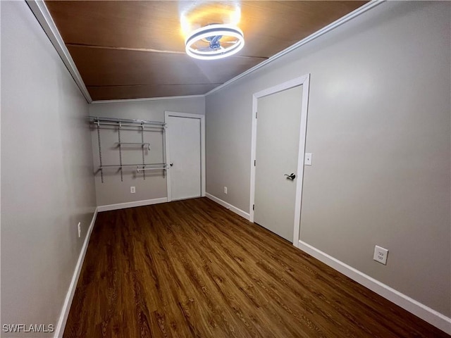 empty room with baseboards, wood finished floors, and ornamental molding