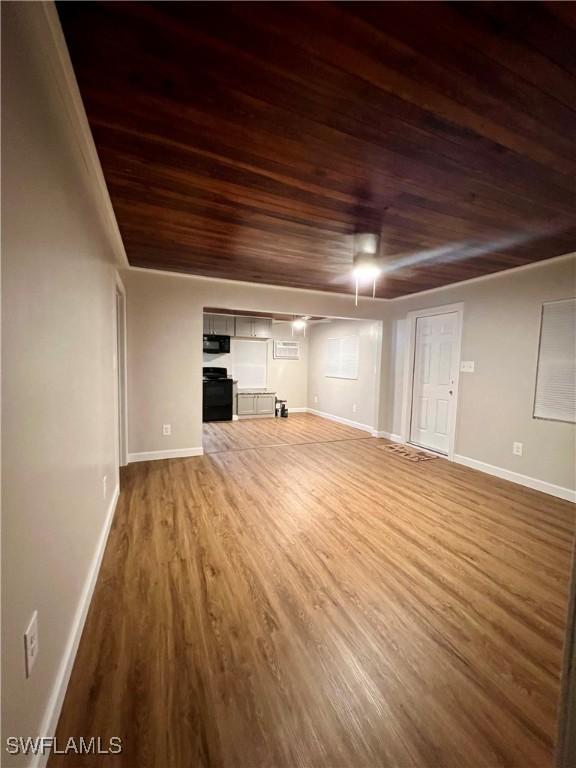 unfurnished living room with wood finished floors, wood ceiling, and baseboards