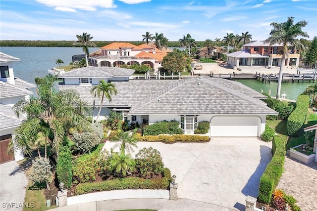 exterior space featuring a residential view, concrete driveway, a water view, and an attached garage