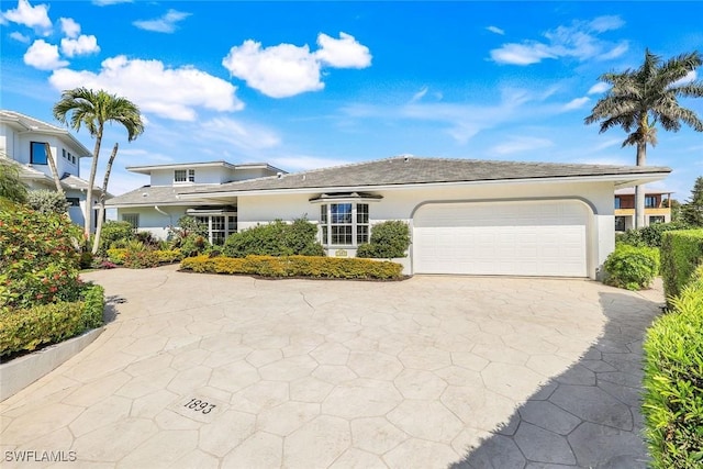 view of front of home featuring an attached garage, concrete driveway, and stucco siding