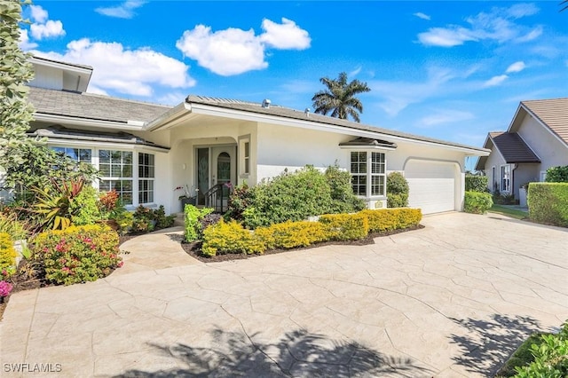 ranch-style house featuring driveway, an attached garage, and stucco siding