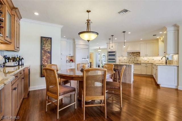 dining space featuring dark wood-style floors, crown molding, recessed lighting, visible vents, and baseboards