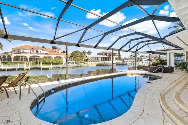 pool featuring a lanai, a water view, and a patio