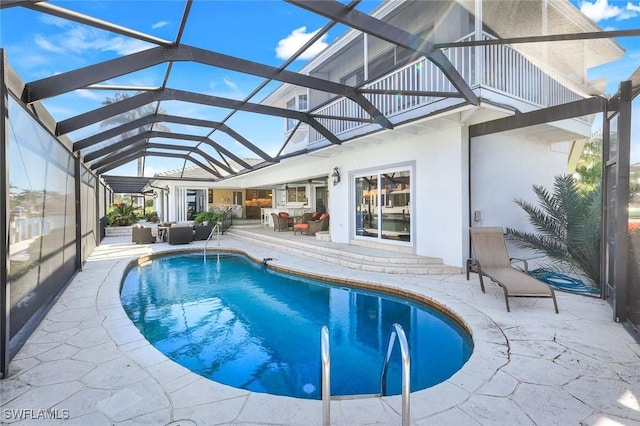 pool with an outdoor hangout area, a patio area, and a lanai