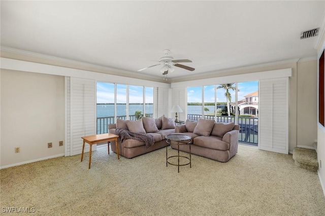 living area featuring carpet floors, visible vents, ornamental molding, ceiling fan, and baseboards