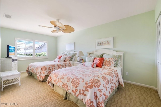 carpeted bedroom with a ceiling fan, a closet, visible vents, and baseboards