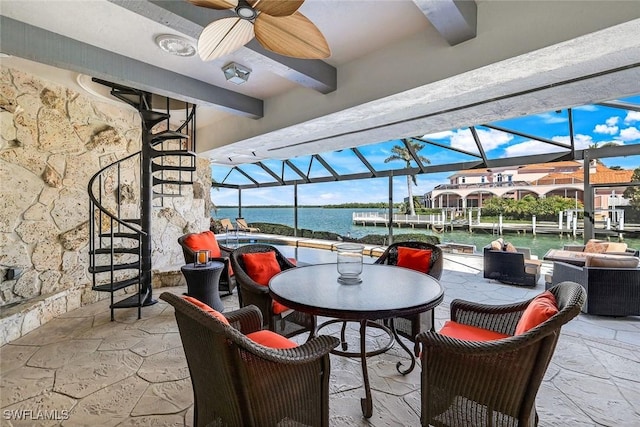 view of patio / terrace with a ceiling fan, a boat dock, a lanai, a water view, and outdoor dining space