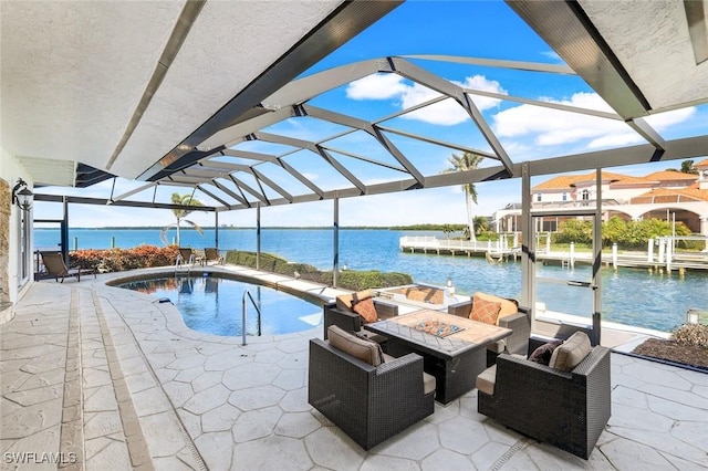 view of swimming pool featuring a lanai, a patio area, an outdoor fire pit, and a water view