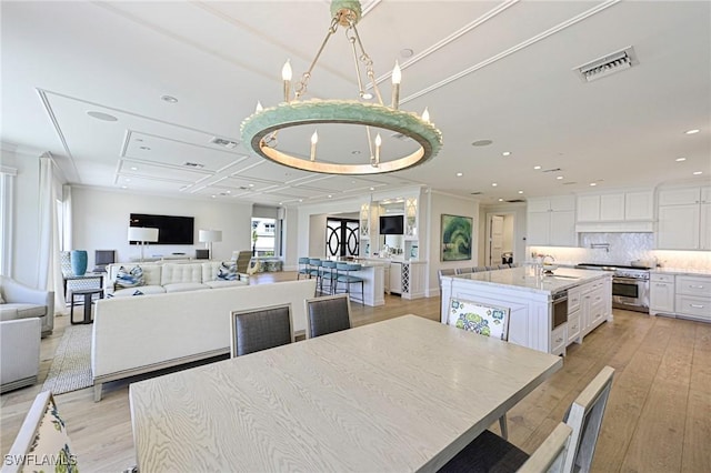 dining space featuring recessed lighting, visible vents, light wood finished floors, and an inviting chandelier