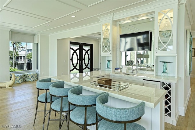 bar featuring baseboards, ornamental molding, light wood-style floors, a sink, and recessed lighting