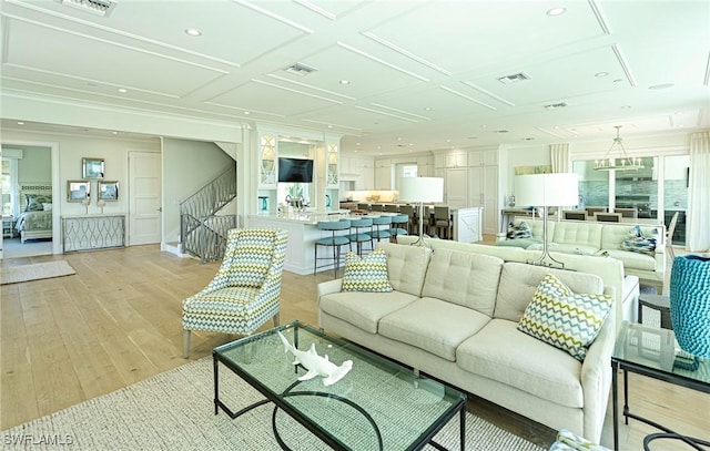 living area featuring recessed lighting, coffered ceiling, visible vents, light wood-style floors, and stairway