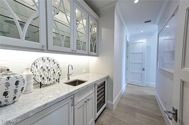 bar with wine cooler, a sink, visible vents, ornamental molding, and backsplash