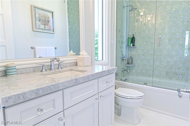 bathroom featuring tile patterned floors, vanity, toilet, and bath / shower combo with glass door