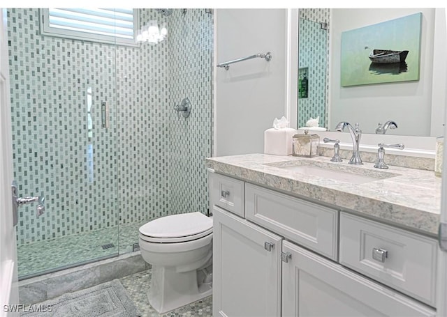 full bath featuring a chandelier, toilet, vanity, a shower stall, and tile patterned floors