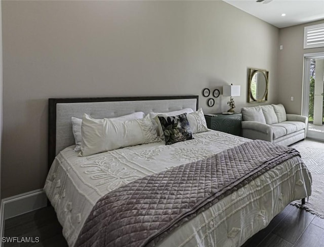 bedroom featuring access to exterior, wood finished floors, and baseboards