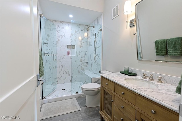 full bathroom with toilet, a marble finish shower, visible vents, and vanity