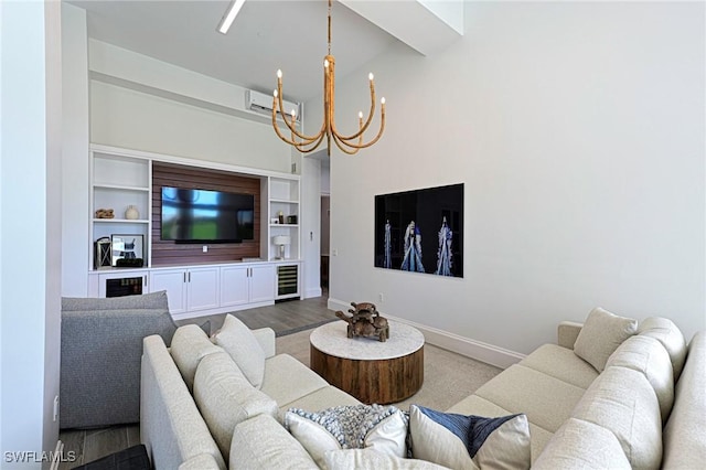 living area featuring baseboards, a wall unit AC, wine cooler, an inviting chandelier, and a high ceiling