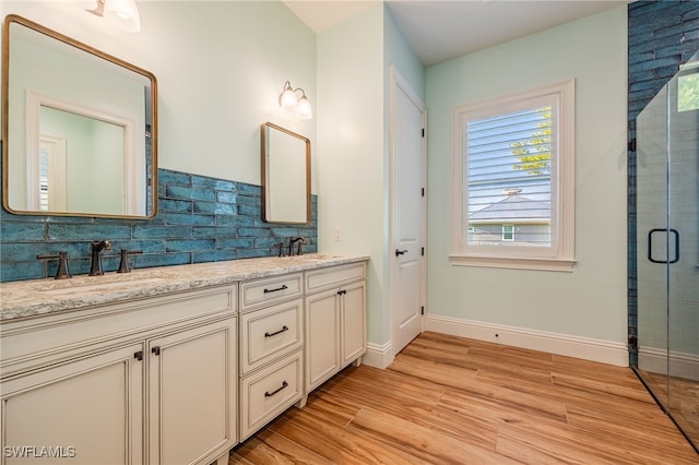 full bathroom with tasteful backsplash, baseboards, a sink, and wood finished floors