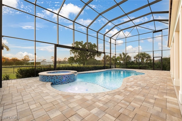 view of pool featuring glass enclosure, a pool with connected hot tub, and a patio