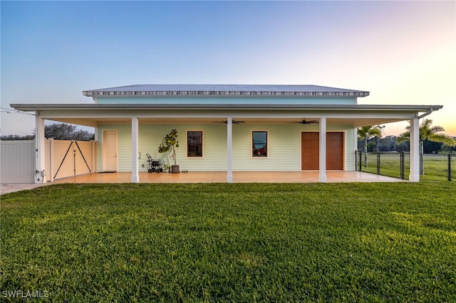 rear view of house with a ceiling fan, a lawn, a gate, fence, and a patio area