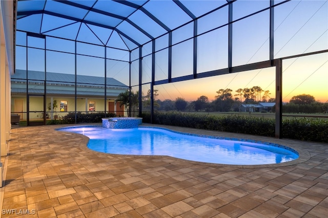 view of pool featuring a pool with connected hot tub, a lanai, and a patio