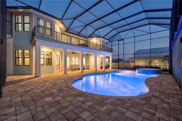 outdoor pool with a patio area, ceiling fan, glass enclosure, and outdoor lounge area