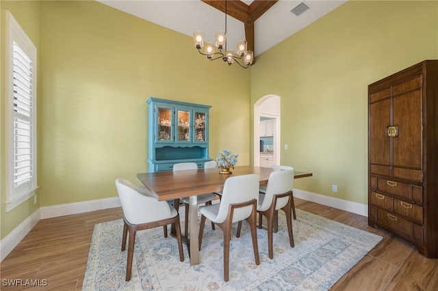 dining area featuring an inviting chandelier, baseboards, visible vents, and light wood finished floors