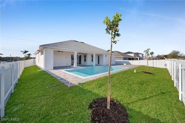 back of house with ceiling fan, a lawn, a fenced backyard, and a fenced in pool