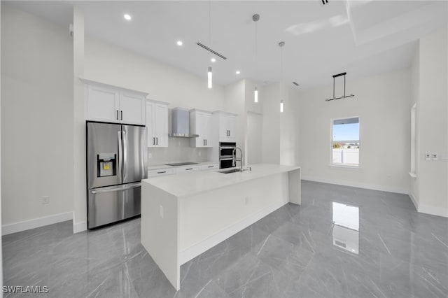 kitchen featuring white cabinets, appliances with stainless steel finishes, marble finish floor, light countertops, and wall chimney range hood