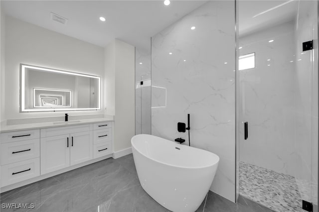 full bath featuring a marble finish shower, marble finish floor, vanity, a freestanding tub, and recessed lighting