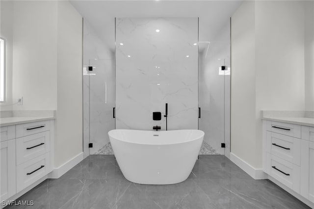 bathroom featuring marble finish floor, a marble finish shower, a soaking tub, and vanity