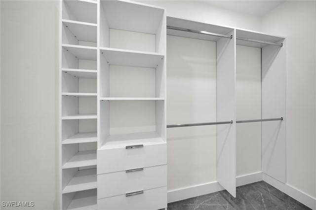 walk in closet featuring marble finish floor