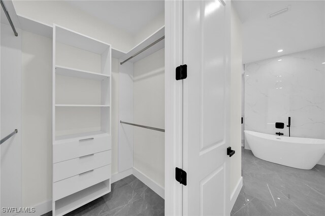 spacious closet featuring marble finish floor