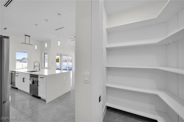 storage area featuring beverage cooler, visible vents, and a sink