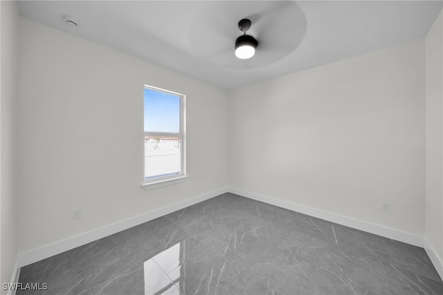 unfurnished room featuring ceiling fan and baseboards