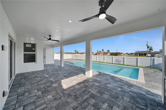 view of pool featuring a patio area, a fenced backyard, and a ceiling fan