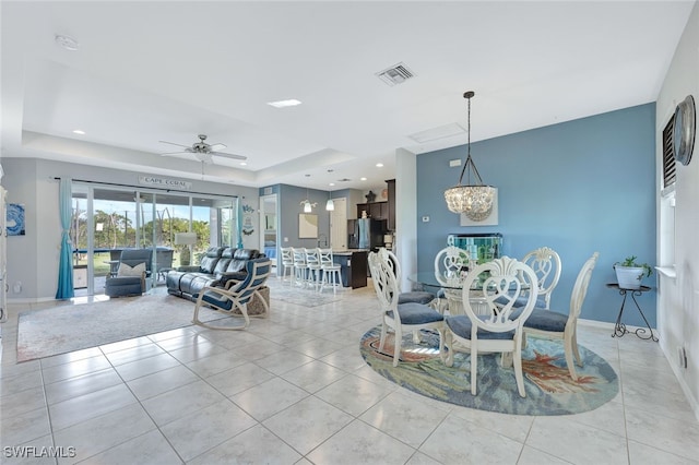 dining area featuring light tile patterned floors, baseboards, visible vents, and a raised ceiling