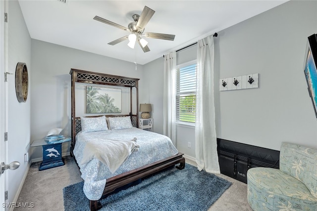 carpeted bedroom with ceiling fan and baseboards