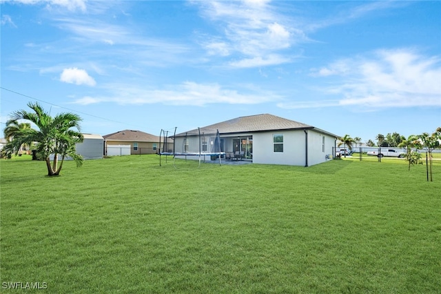 view of yard with a trampoline and fence