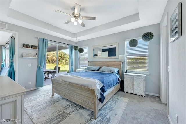 bedroom with a tray ceiling, light carpet, ceiling fan, access to outside, and baseboards