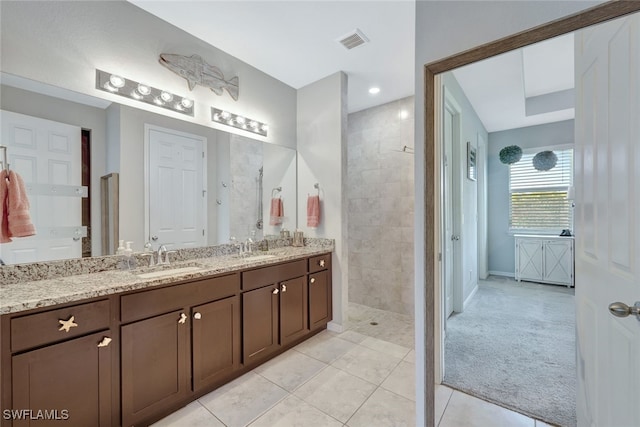 full bath with double vanity, visible vents, tile patterned flooring, walk in shower, and a sink