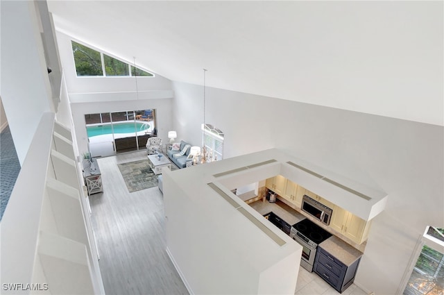 living room featuring light wood-style flooring and high vaulted ceiling