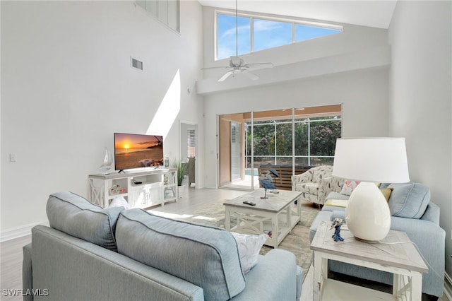 living area featuring plenty of natural light, wood finished floors, visible vents, and ceiling fan