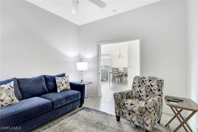 living room featuring baseboards, a ceiling fan, and wood finished floors