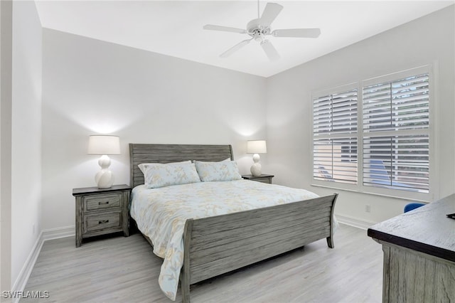 bedroom with ceiling fan, light wood-type flooring, and baseboards