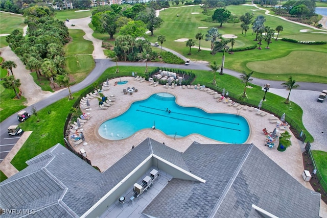 pool with view of golf course, fence, and a patio